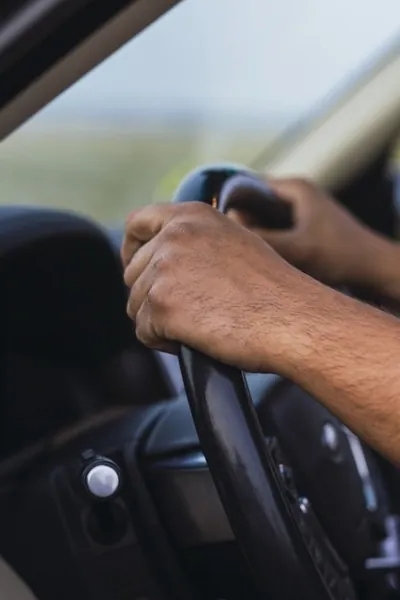 Mãos ao volante de um veículo
